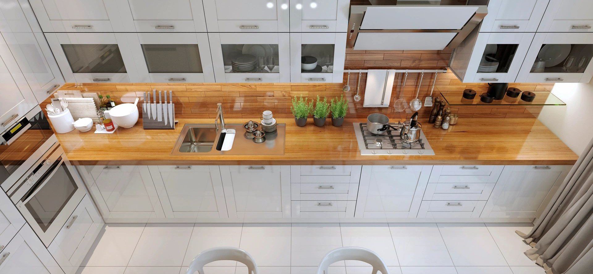 A kitchen with white cabinets and wooden counters.